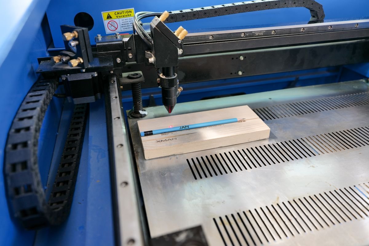 Desktop laser cutter cutting wood in a school lab